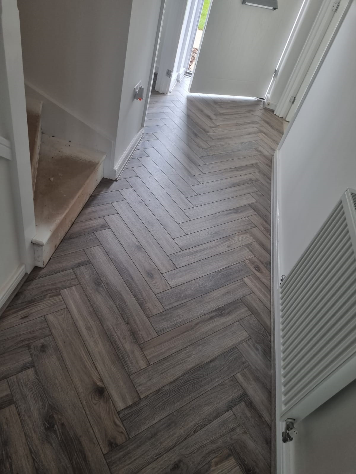 Volcanic oak herringbone in dark hallway